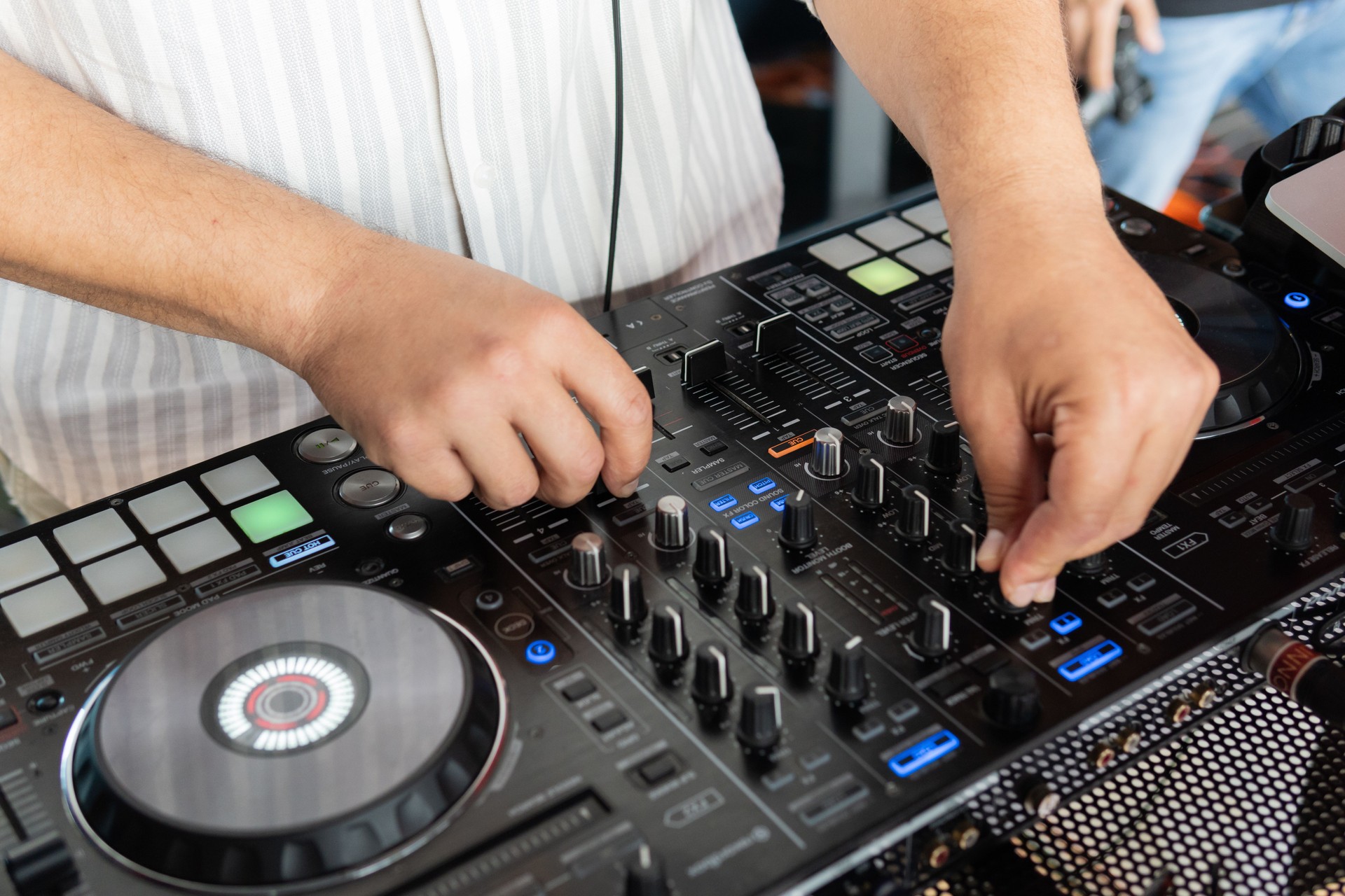 DJ adjusting mixer controls during live performance. Electronic concept.